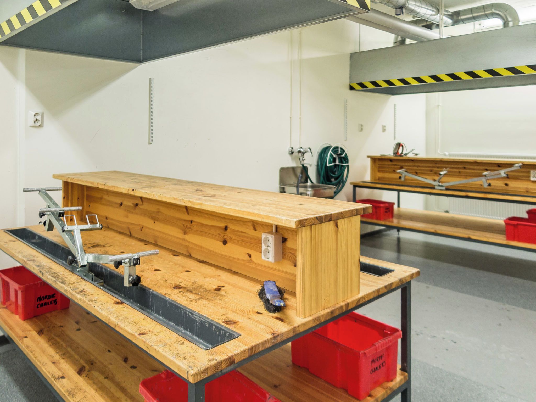 Een werkplaats met een werkbank, gereedschap en opbergkisten.