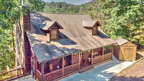 A cabin with a porch, a chimney, and a small shed. - Riverfront Mtn Retreat Hot Tub/Fireplaces/King Beds/Tubing/Fishing/Spacious (Ellijay)