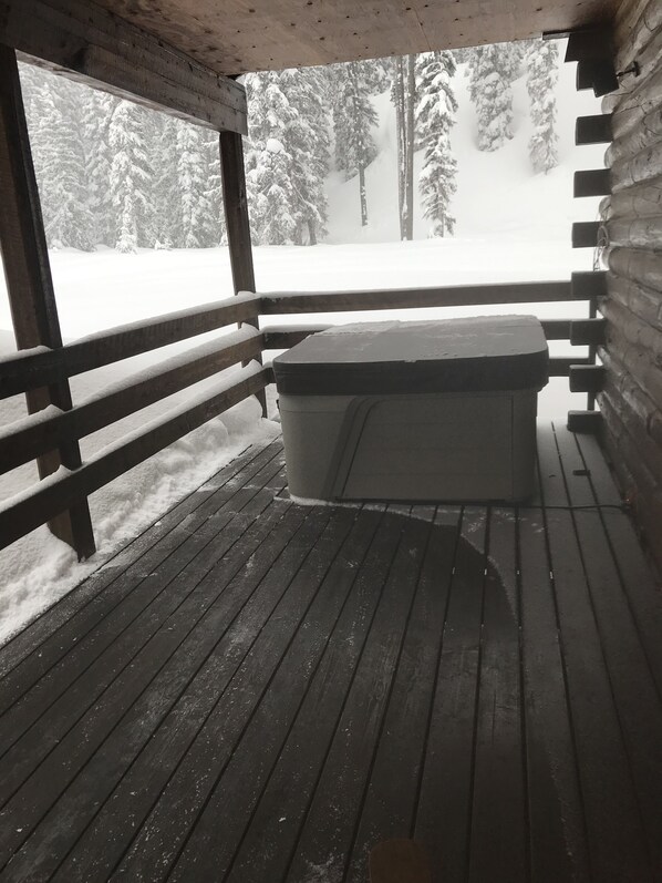 A wooden deck with a bench and a hot tub. - Base Camp to Yellowstone and the Beartooth Pass (Cooke City)
