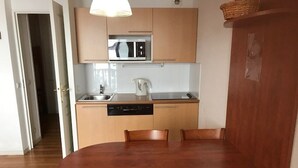 Una cocina moderna con armarios de madera, microondas integrado y lavavajillas.