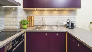 A modern kitchen with purple cabinets, a stainless steel sink, and a coffee maker. - Kliffhoog 5 from A&M - Kliffhoog 5 (Kampen (Sylt))
