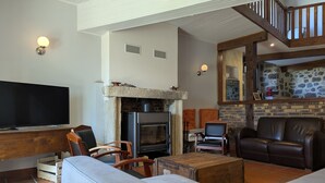 Ein Wohnzimmer mit Kamin, Fernseher und einer Treppe.
