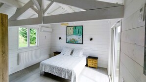Een slaapkamer met een bed, twee nachtkastjes, een radiator en een raam.