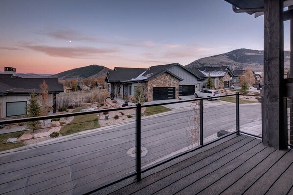 A residential area with houses, a driveway, and a wooden deck.