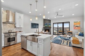 A modern kitchen with a central island, stainless steel appliances, and pendant lighting.