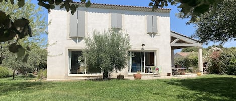 Une maison à deux étages, dotée d’un toit plat, de grandes fenêtres et d’un porche couvert.