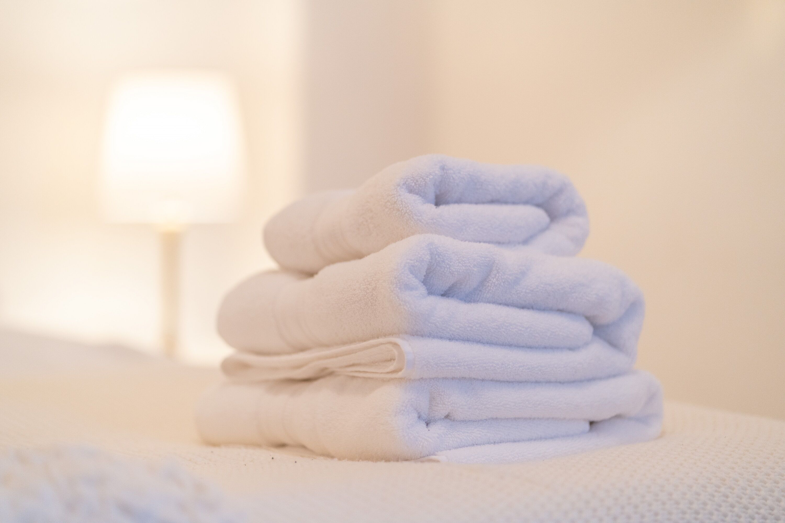 A stack of folded towels on a textured surface.