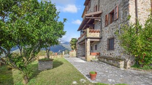 A stone building with a balcony, a potted plant, and a view of the mountains. - 4 bedroom cozy home in Camaiore (Camaiore)