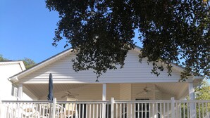 Une maison blanche avec un garage fermé et un balcon.