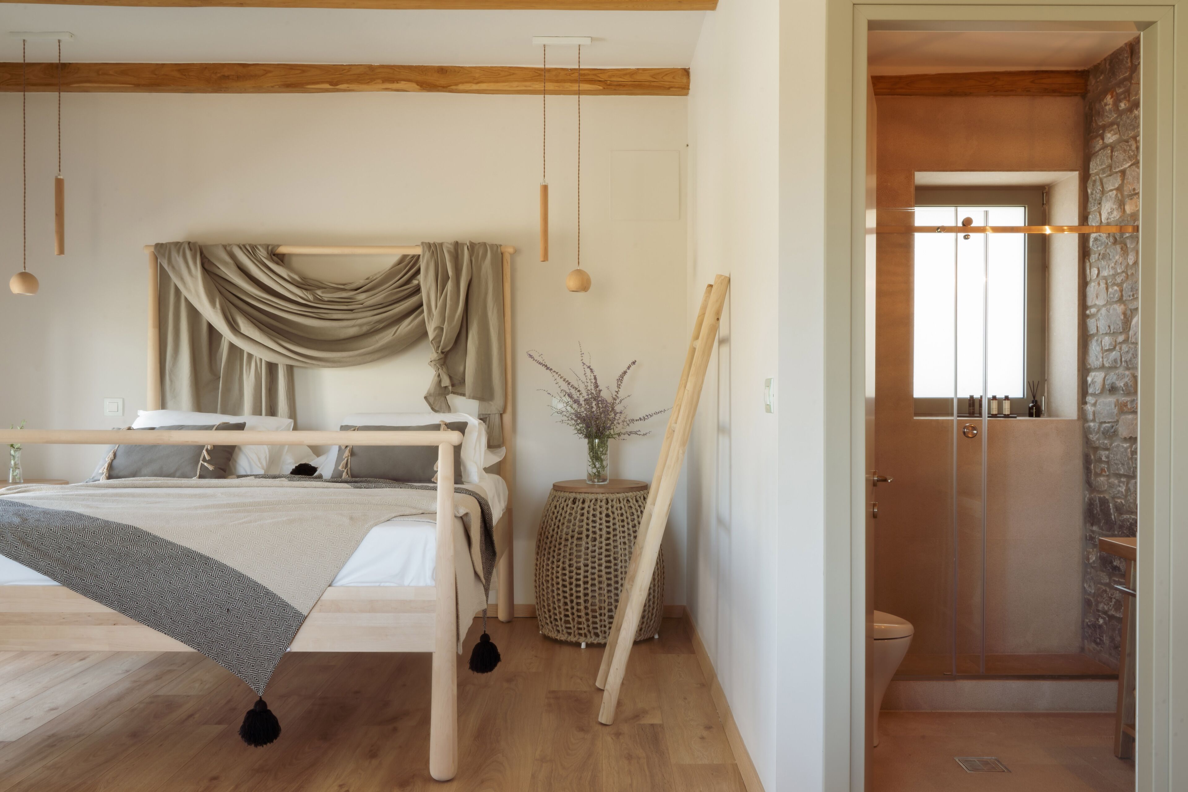 A bedroom with a bed, bedside table, and a view into a bathroom.
