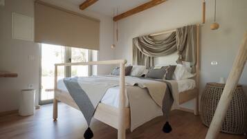 Een slaapkamer met een houten bed, een groot raam en uitzicht op de omgeving.