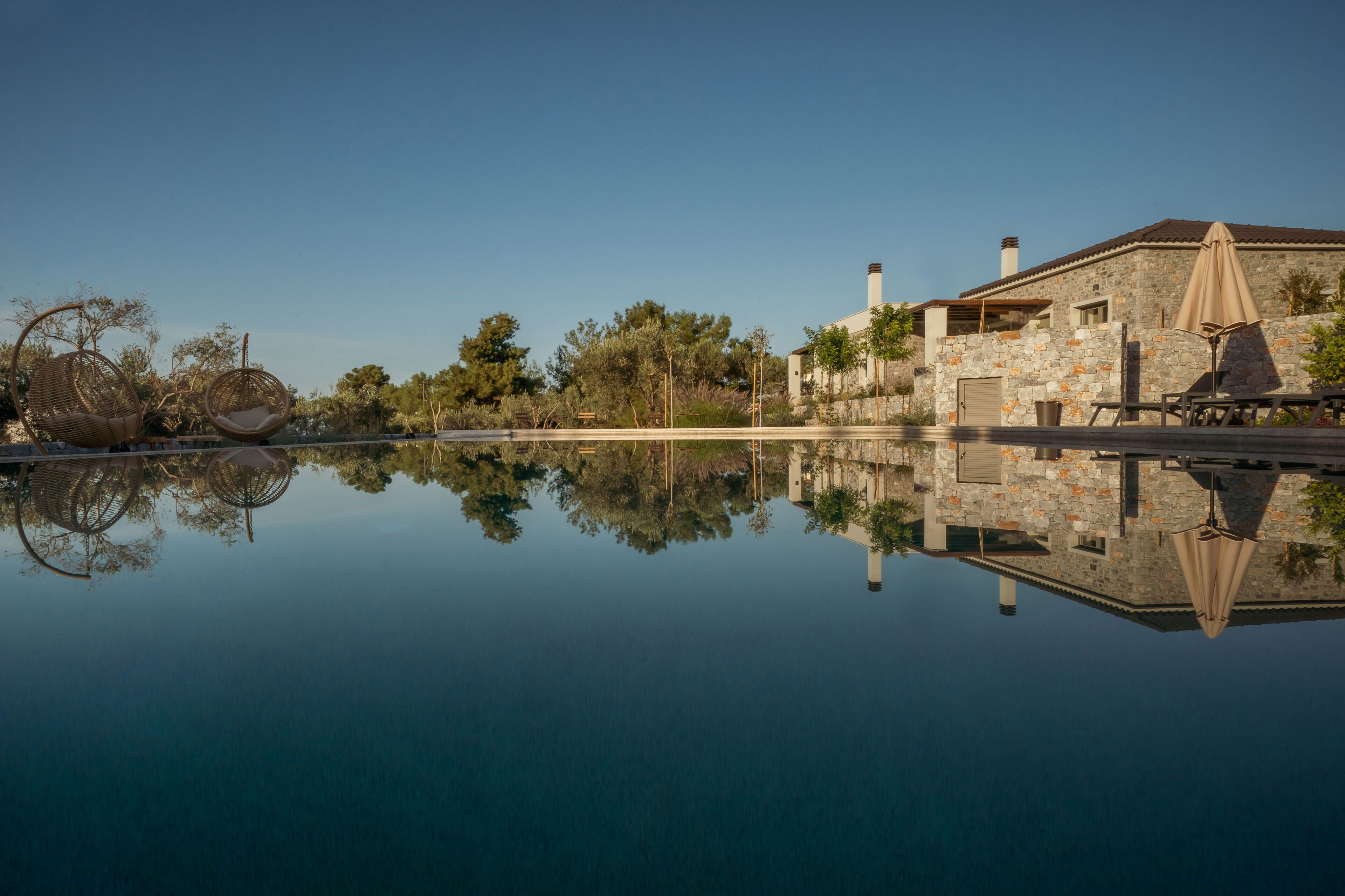 Un edificio de piedra con una piscina que refleja su estructura.