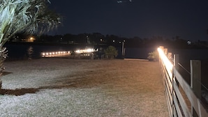 A nighttime view of a beach area with a wooden fence, a pathway, and a body of water. - Sunny San Leon Casita!! (San Leon)