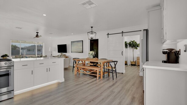 A modern kitchen with white cabinetry, a wooden dining table, and a built-in oven. - Level up your Old Town stay- Walk to bars- 2 Kings (Scottsdale)