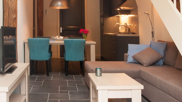 A modern interior with a dining area, a sofa, and a staircase.
