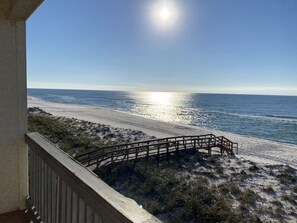 A beach view from a balcony with a wooden deck and railing. - Right ON world’s whitest beach, Pensacola Beach, Florida. (Pensacola Beach)