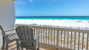 A balcony with a view of a beach, a chair, and a railing. - Vacation home just steps away from the Gulf (Pensacola Beach)