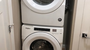A stacked washer and dryer unit in a laundry room. - Riverside Cabin 2 - (Brand New Construction) (Grants Pass)