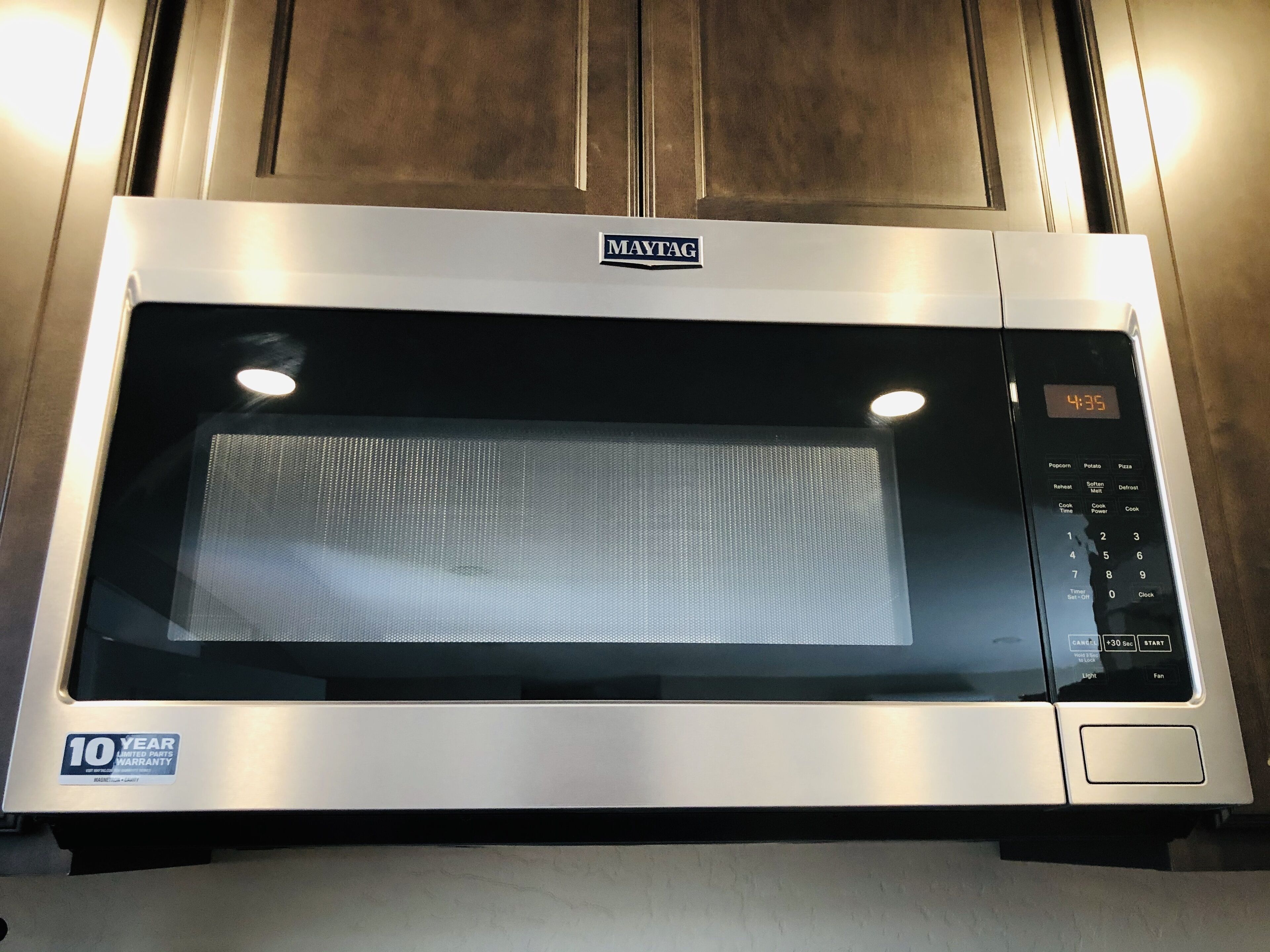 En Maytag-mikrovågsugn med digital display och kontrollpanel.