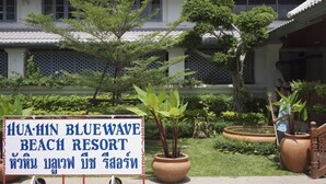A sign for Hua Hin Bluewave Beach Resort with a garden in front.