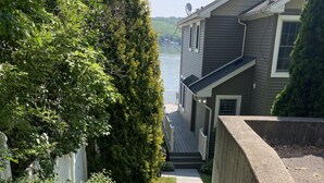 A staircase leading to a deck with a view of a lake and a house. - Relax lakeside at our spacious Geneseo house on  Conesus Lake (Conesus)