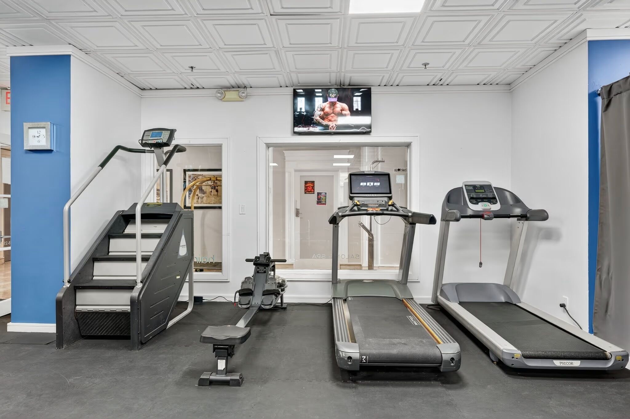 Ett gym med löpband, en crosstrainer och en trappmaskin.