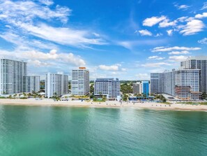 Eine Küstenstadt mit Wolkenkratzern, einem Sandstrand und blauem Himmel.