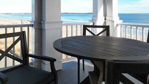 A covered outdoor seating area with a view of the beach.