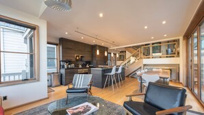 A modern open-plan living area with a kitchen, dining space, and a staircase leading to an upper level. - Old Town Private Home by Luxury Mountain Destinations (Park City)