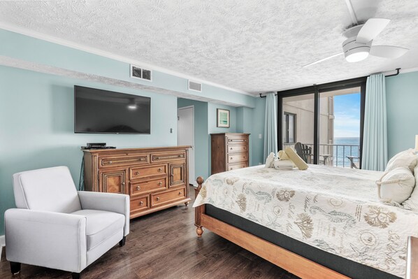 Une chambre avec un grand lit, une commode, un téléviseur et une vue sur l’extérieur.