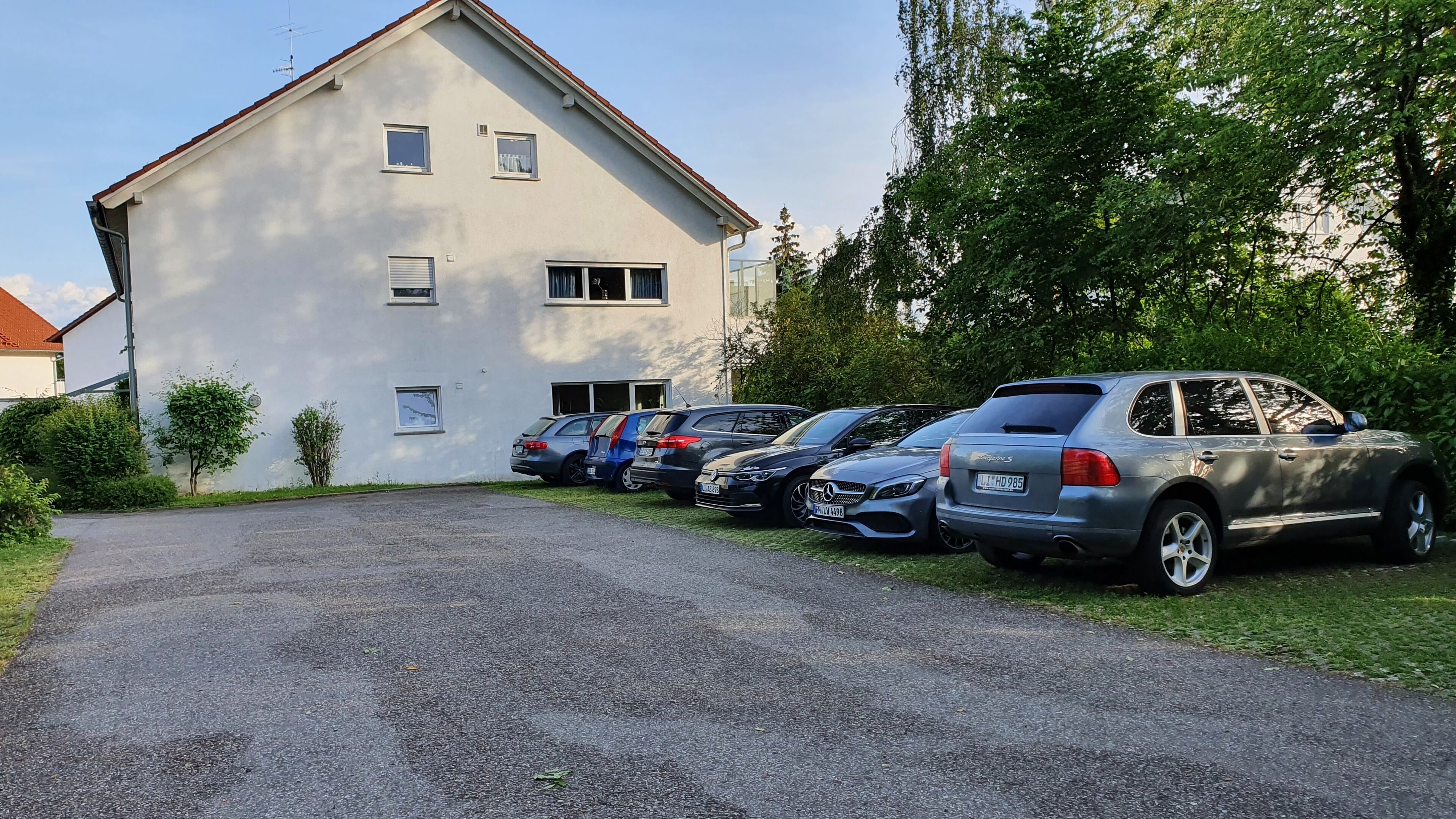 Ein Gebäude mit mehreren Fenstern und einem Parkplatz mit einigen Autos.