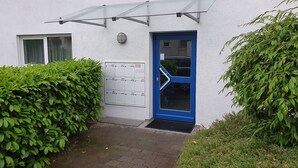 Ein Gebäude mit blauer Tür, einem Fenster und mehreren Briefkästen.