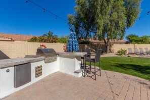 Enjoy al fresco dining on the patio, featuring a barbecue grill and comfortable seating for two.