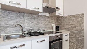 Een moderne keuken met een roestvrijstalen spoelbak, een vaatwasser en een oven.