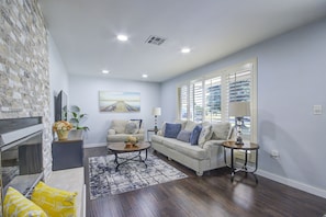Relax in this stylish living room with a cozy seating area, fireplace, and large window.