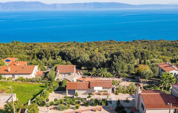 A coastal village with terracotta-roofed houses, lush greenery, and a view of the sea. - Lovely home in Ravni with WiFi (Ravni)