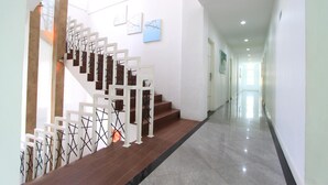 A modern interior with a staircase, a hallway, and artwork on the walls.