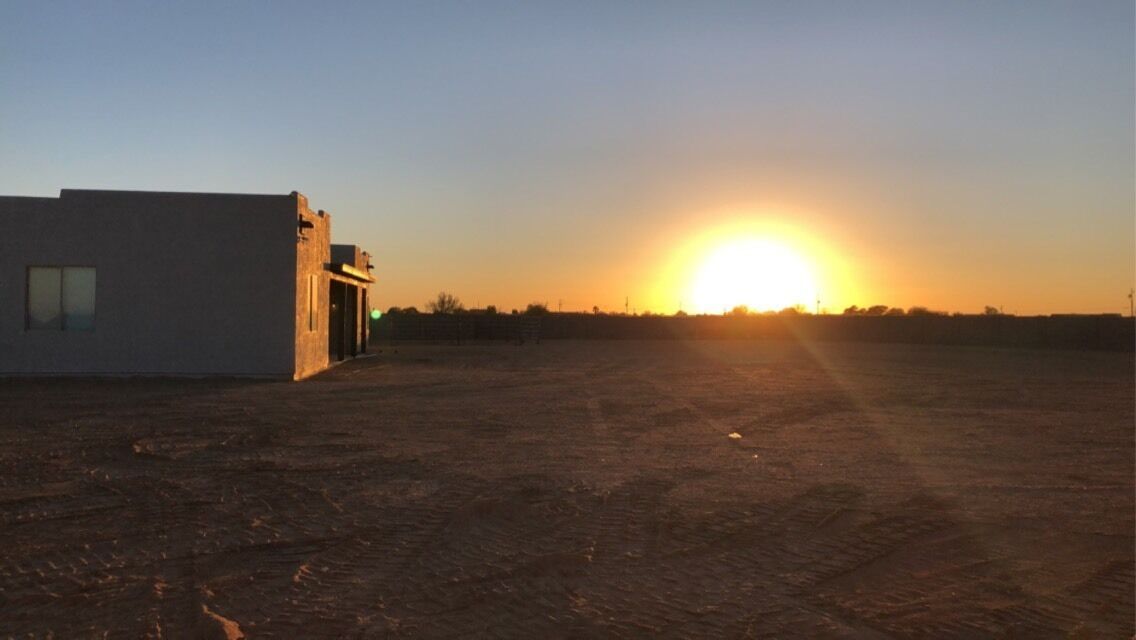 A building with a flat roof and a large open area in front.