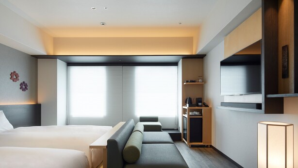 A modern hotel room with a bed, sofa, desk, and built-in TV. - Agora Kyoto Shijo (Kyoto)