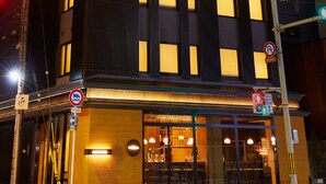 A building with illuminated windows, a no parking sign, and a pedestrian crossing. - Agora Kyoto Shijo (Kyoto)