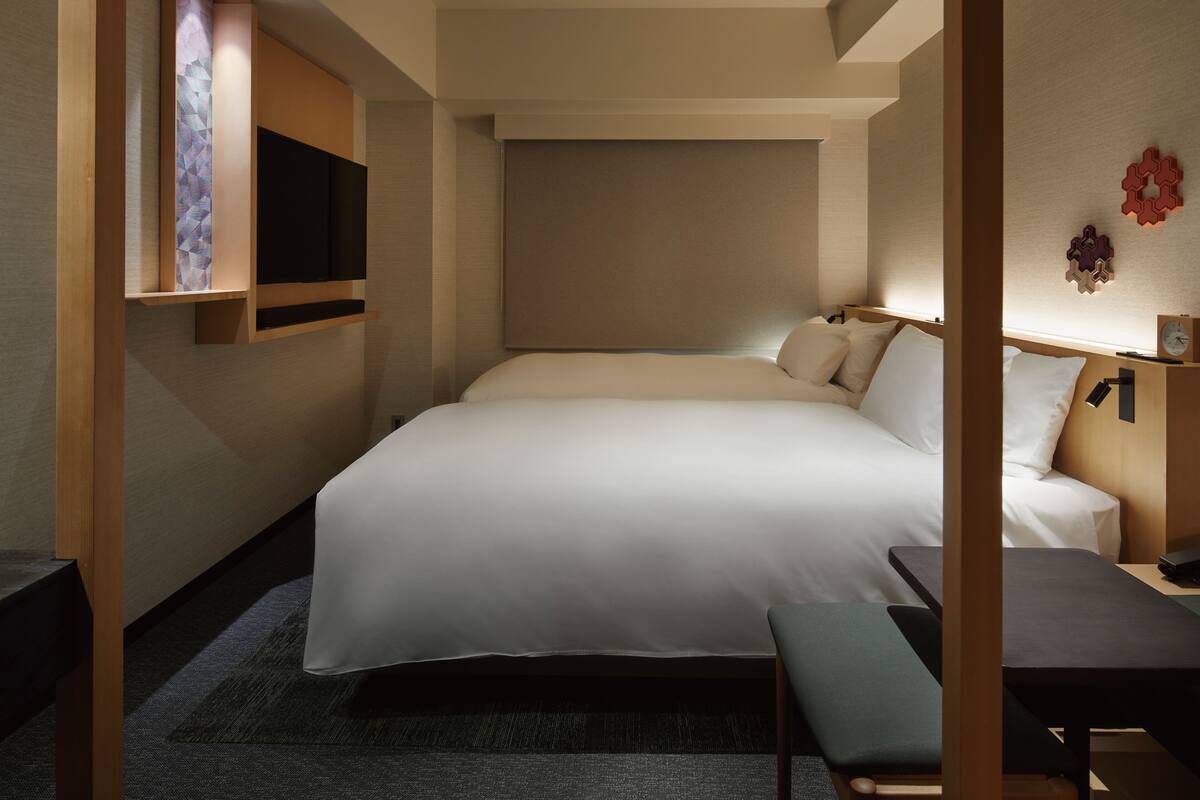 Een moderne hotelkamer met een groot bed, een bureau en een televisie.