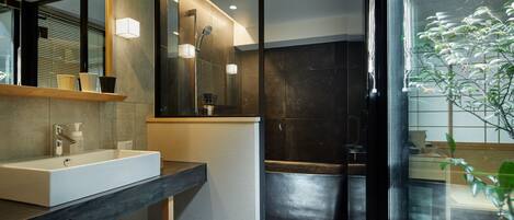 A modern bathroom with a large mirror, a sink, and a shower area.