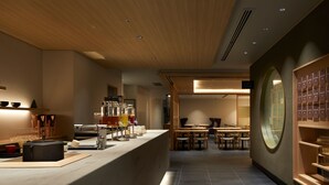 Un intérieur moderne comprenant un comptoir d’accueil, un espace salon et une grande fenêtre.
