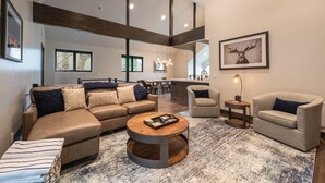 A spacious living room with a sectional sofa, a round coffee table, and a fireplace. - DV Loop Old Town Home by Luxury Mountain Destinations (Park City)