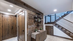 A modern interior with wooden paneling, a staircase, and a built-in shelf with plants. - DV Loop Old Town Home by Luxury Mountain Destinations (Park City)