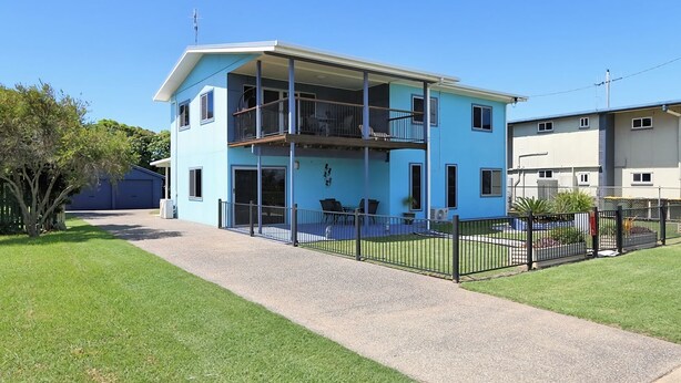 A two-story building with a balcony, a covered patio, and a fenced yard. - 24 Lihs Street Elliott Heads (ELLIOTT HEADS)