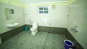 A bathroom with a toilet, sink, and a window. - Deluxe Double Room In British Bungalow (Vythiri)