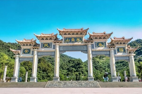 A traditional Chinese archway with inscriptions, set against a backdrop of lush green hills. - Bafaimile Hotel (Shiyan Hongfa World Branch) (Shenzhen)