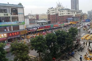 A busy urban street with various shops and buildings. - Bafaimile Hotel (Shiyan Hongfa World Branch) (Shenzhen)