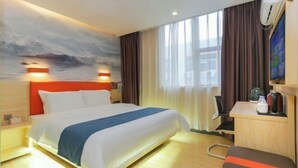 A hotel room with a bed, a desk, a chair, a coffee maker, and a painting on the wall. - Bafaimile Hotel (Shiyan Hongfa World Branch) (Shenzhen)